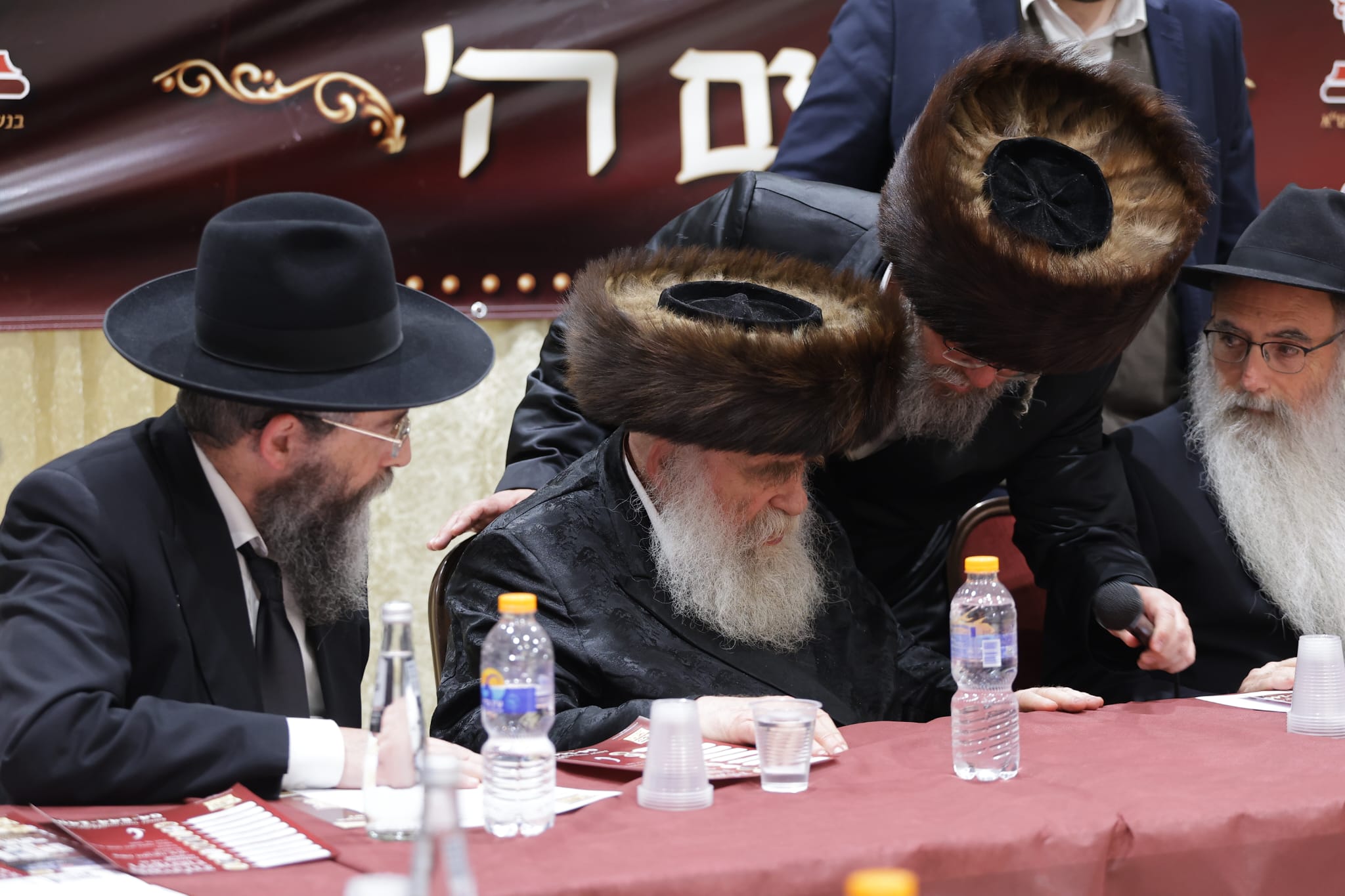 רבני קרית אתא יושבים סביב שולחן בכינוס של קופת החסד